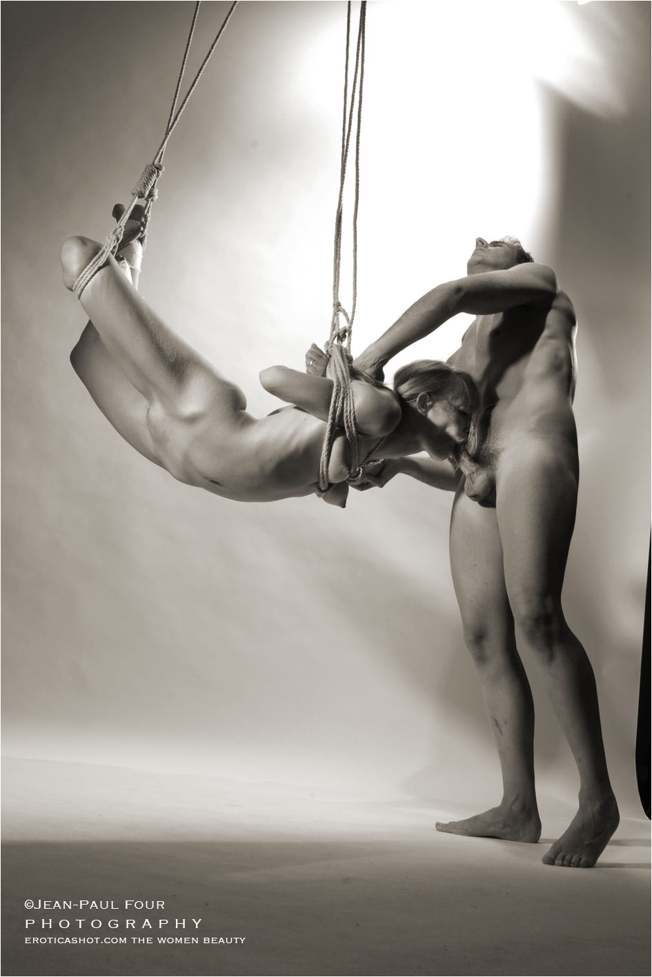 a blonde naked sucks a man naked, Melanie and O, blowjob in the air, gynecological examination, bondage, shibari blowjob, pict by ©Jean-Paul Four